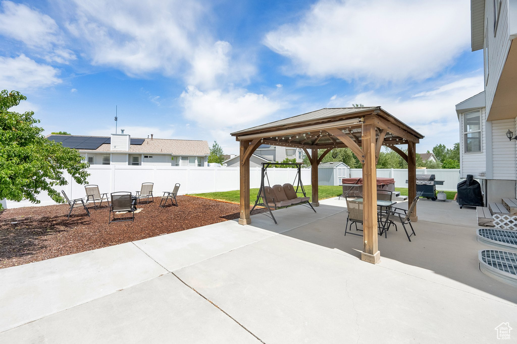 Fenced backyard with a gazebo, a patio, and outdoor dining space