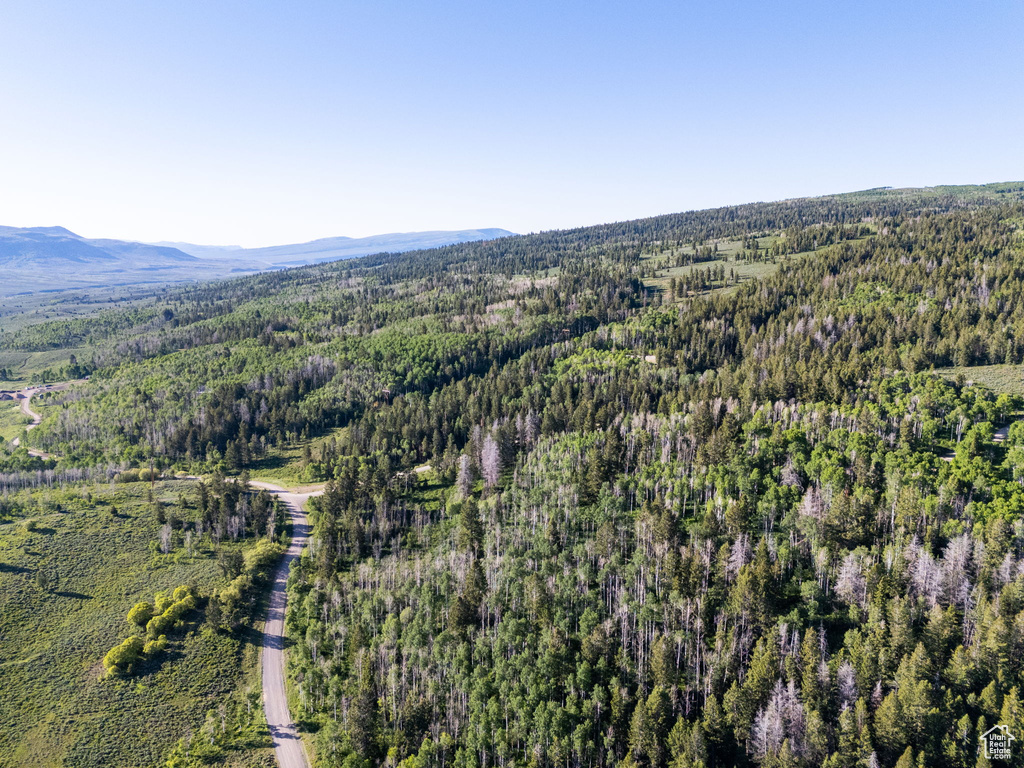View of property location with a forest and a mountain backdrop