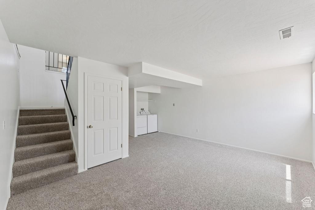 Finished basement featuring washer and dryer, carpet, and stairs