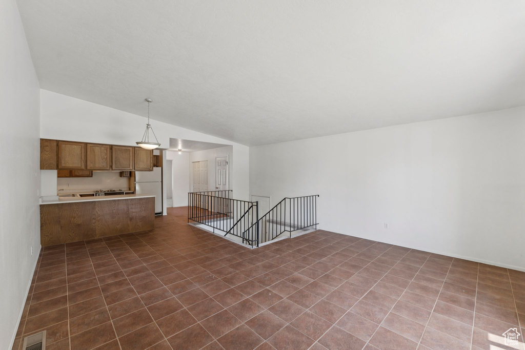 Unfurnished living room featuring lofted ceiling