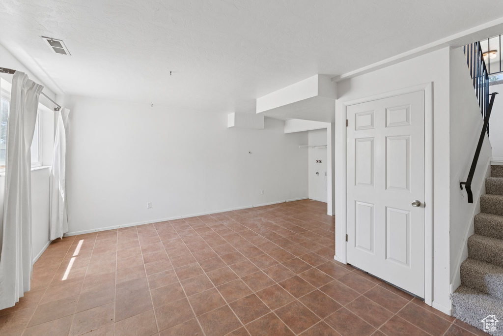 Unfurnished room featuring stairway and tile patterned floors