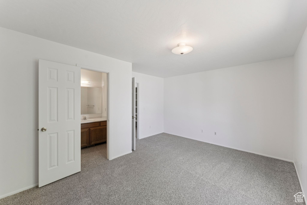 Unfurnished bedroom with light colored carpet and ensuite bath