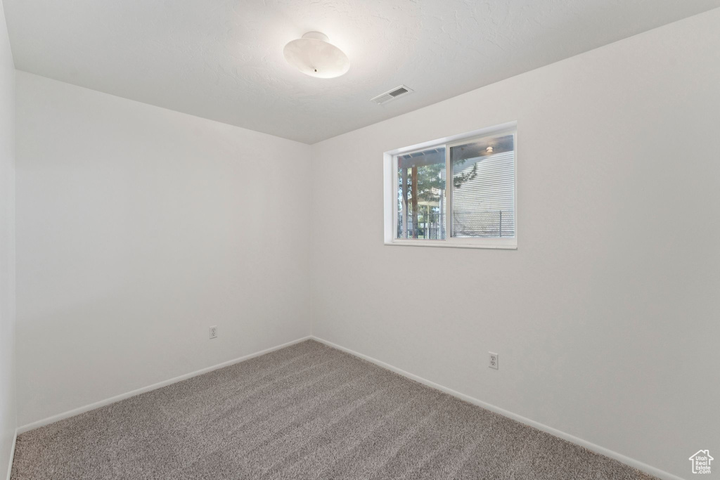 Carpeted spare room with baseboards