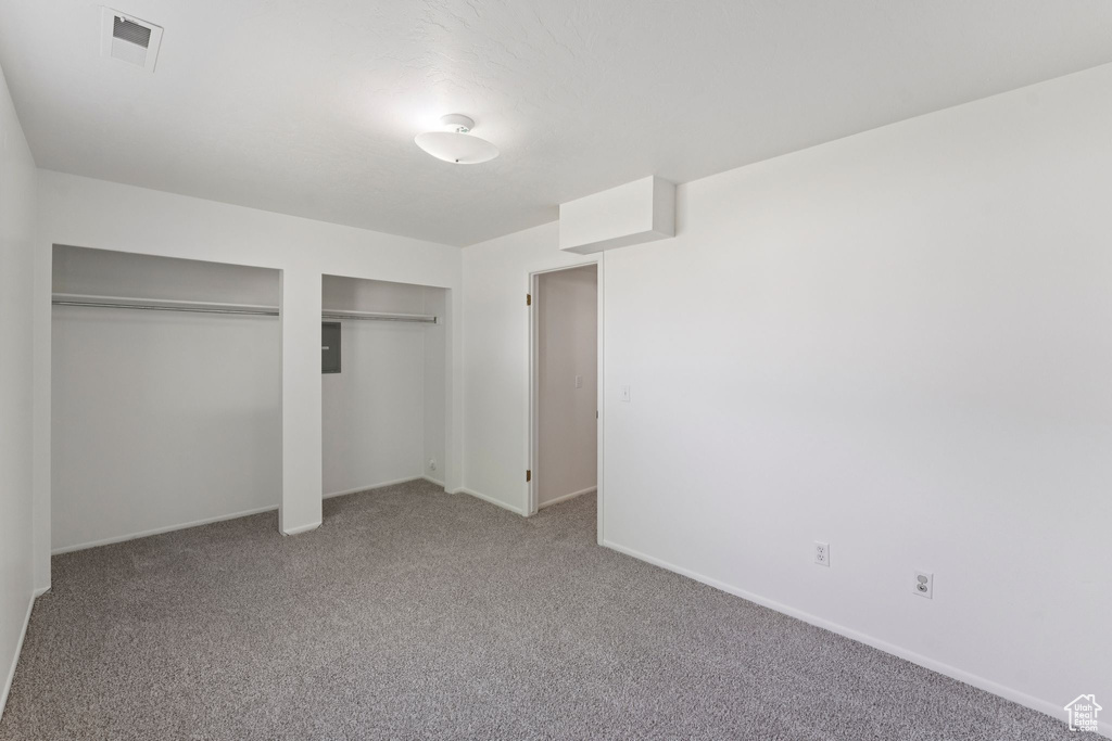 Unfurnished bedroom featuring multiple closets and carpet