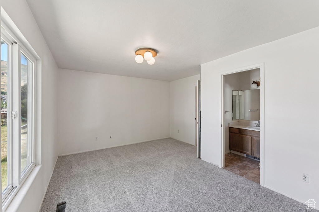 Unfurnished bedroom featuring carpet and ensuite bath