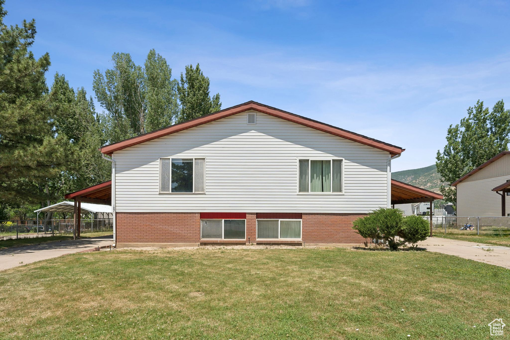 View of property exterior with concrete driveway, brick siding, and an attached carport