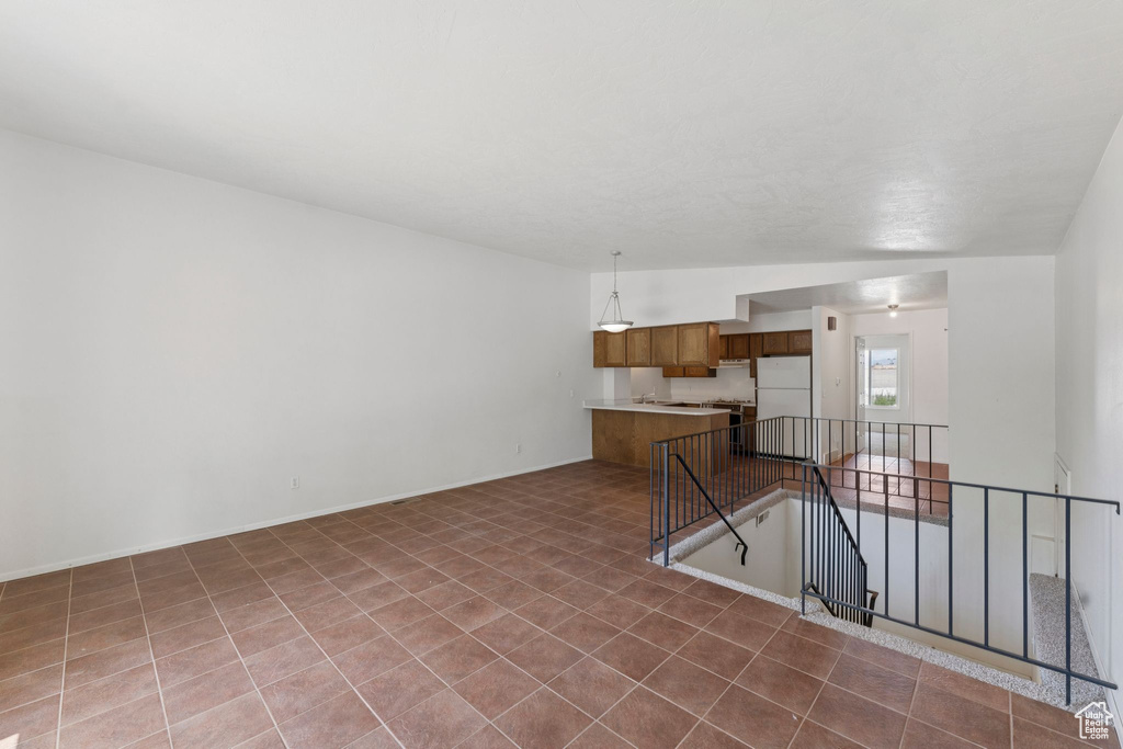 Unfurnished living room featuring baseboards