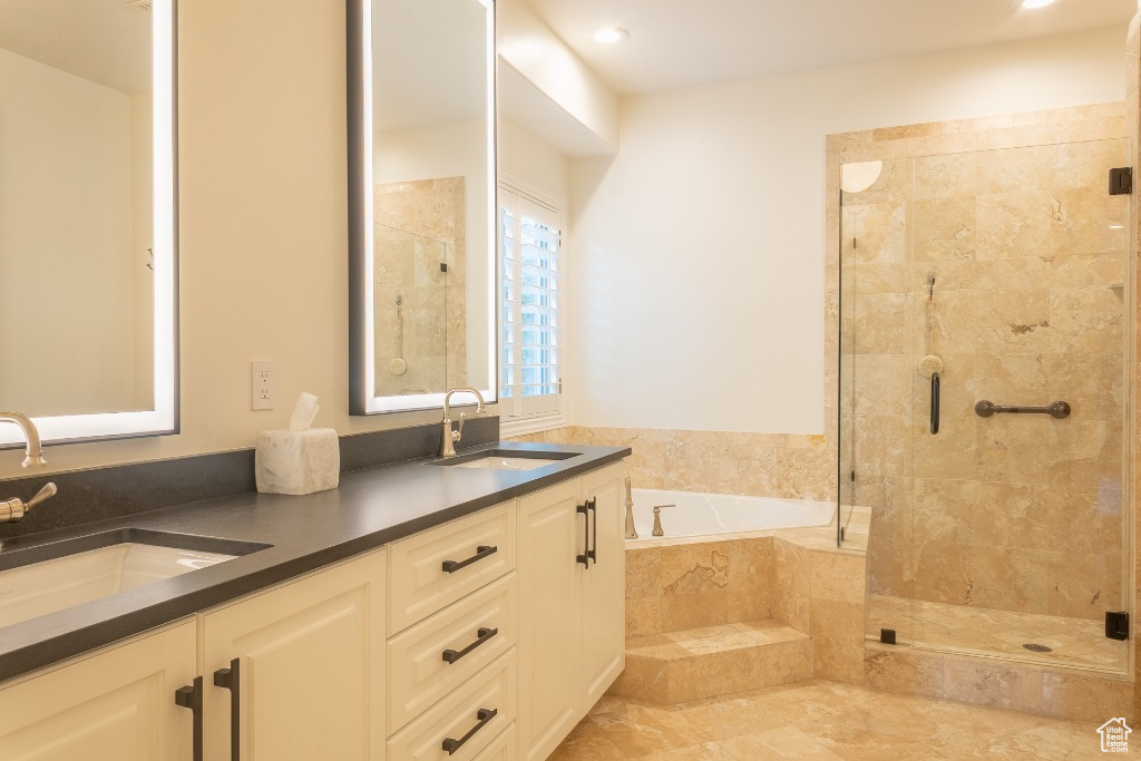 Full bathroom featuring a bath, a shower stall, double vanity, and recessed lighting