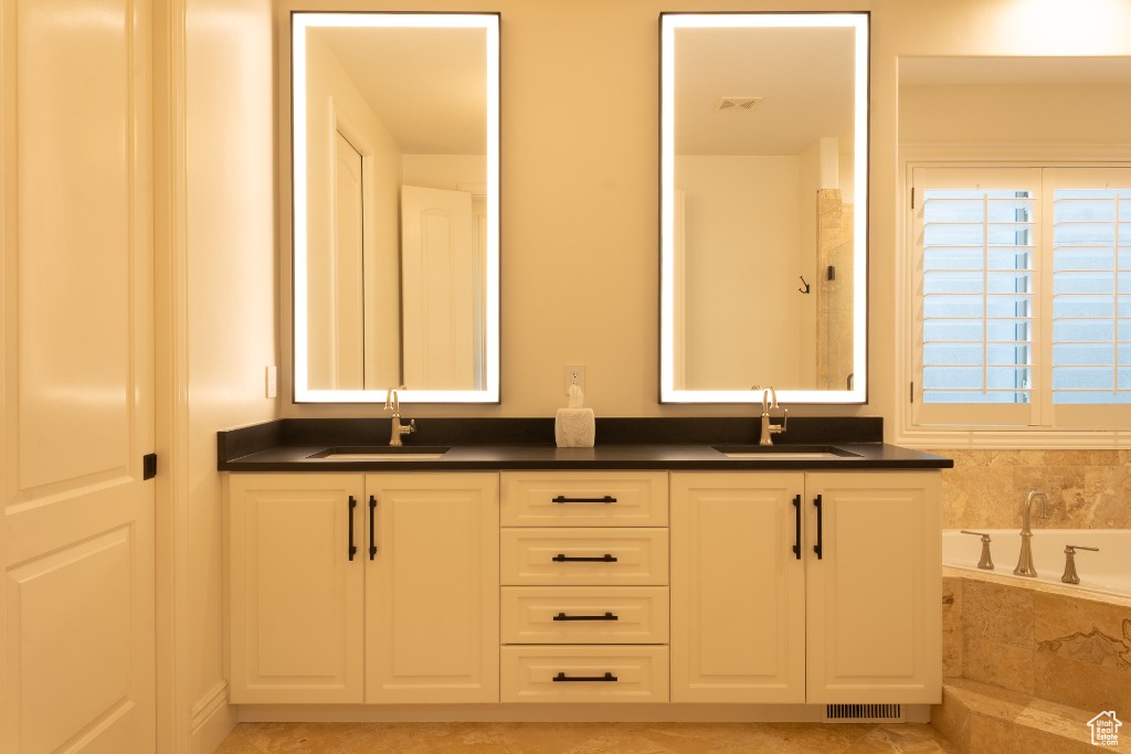 Full bathroom featuring double vanity and a bath