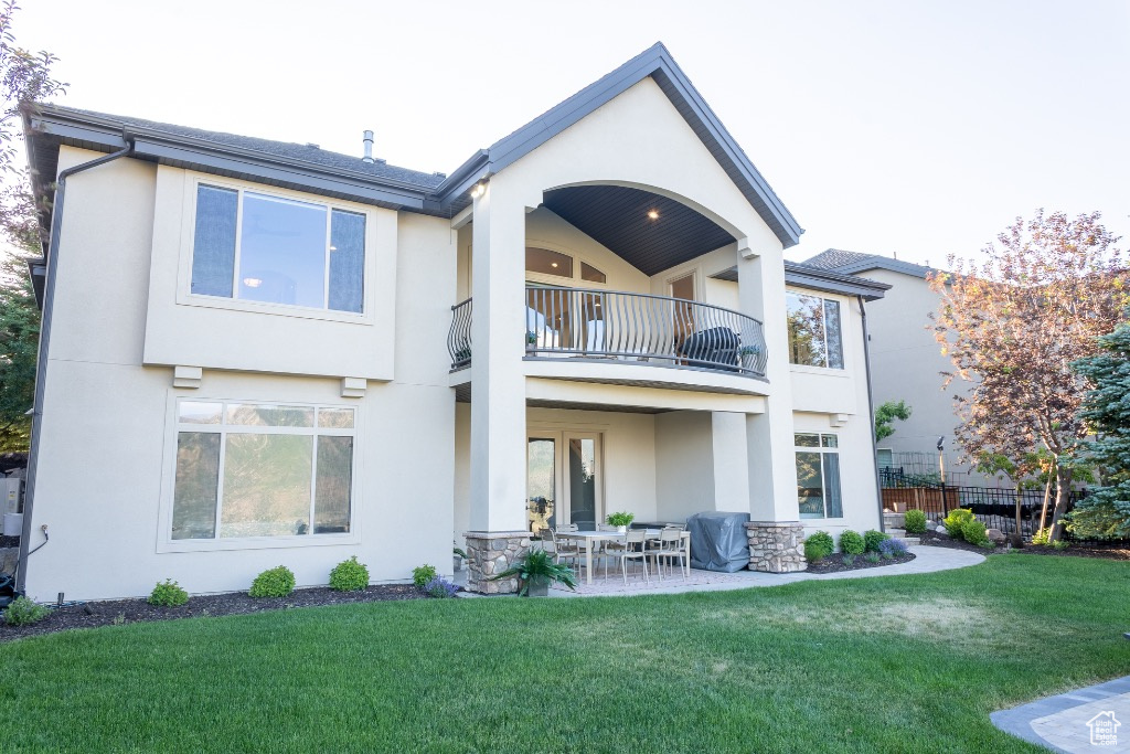 Back of house featuring a balcony, stucco siding, and a patio area