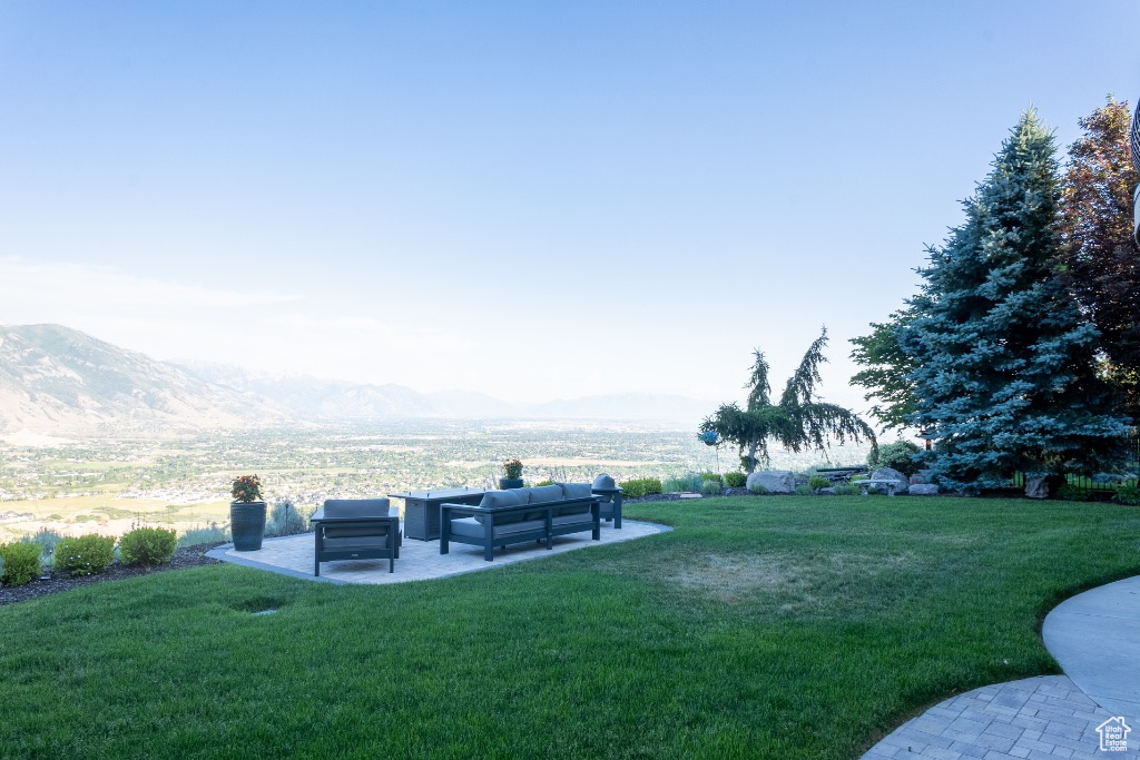 View of green lawn featuring an outdoor hangout area, a mountain view, and a patio area