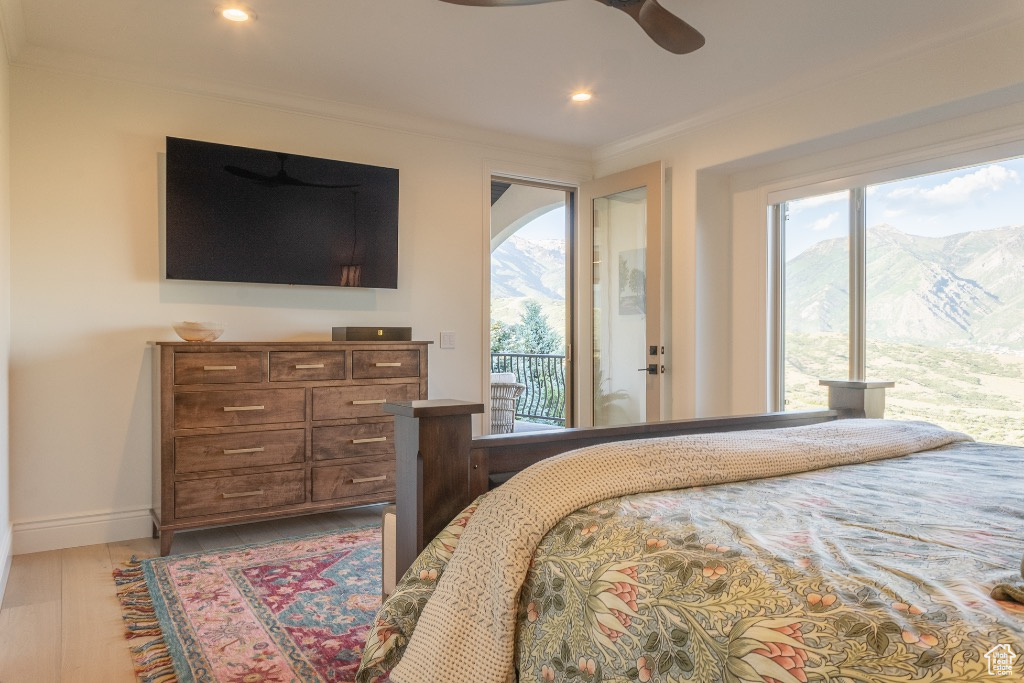 Bedroom featuring access to exterior, multiple windows, wood finished floors, crown molding, and recessed lighting