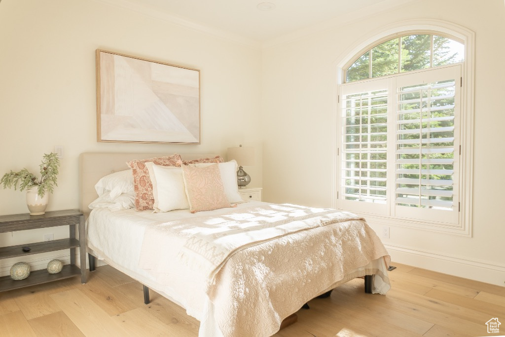 Bedroom featuring wood finished floors and ornamental molding