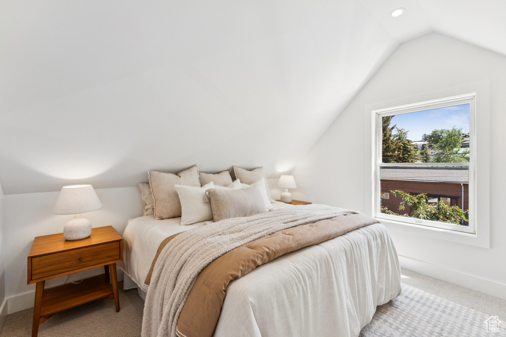 Bedroom with lofted ceiling and carpet flooring