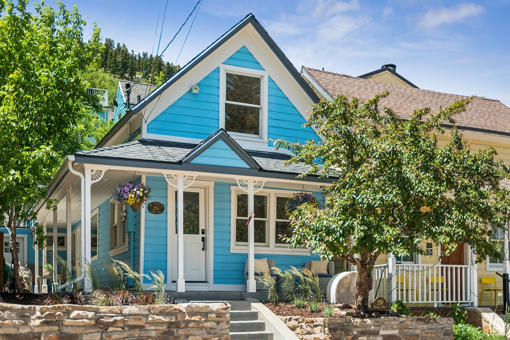 View of front of home featuring a porch and roof with shingles
