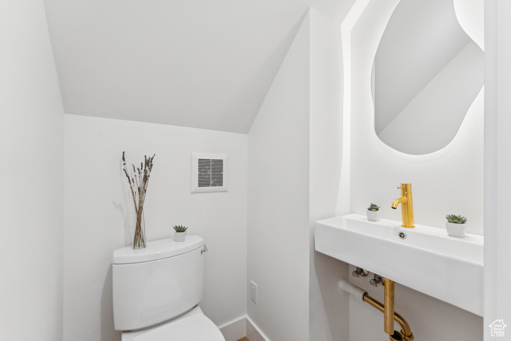 Half bath featuring lofted ceiling