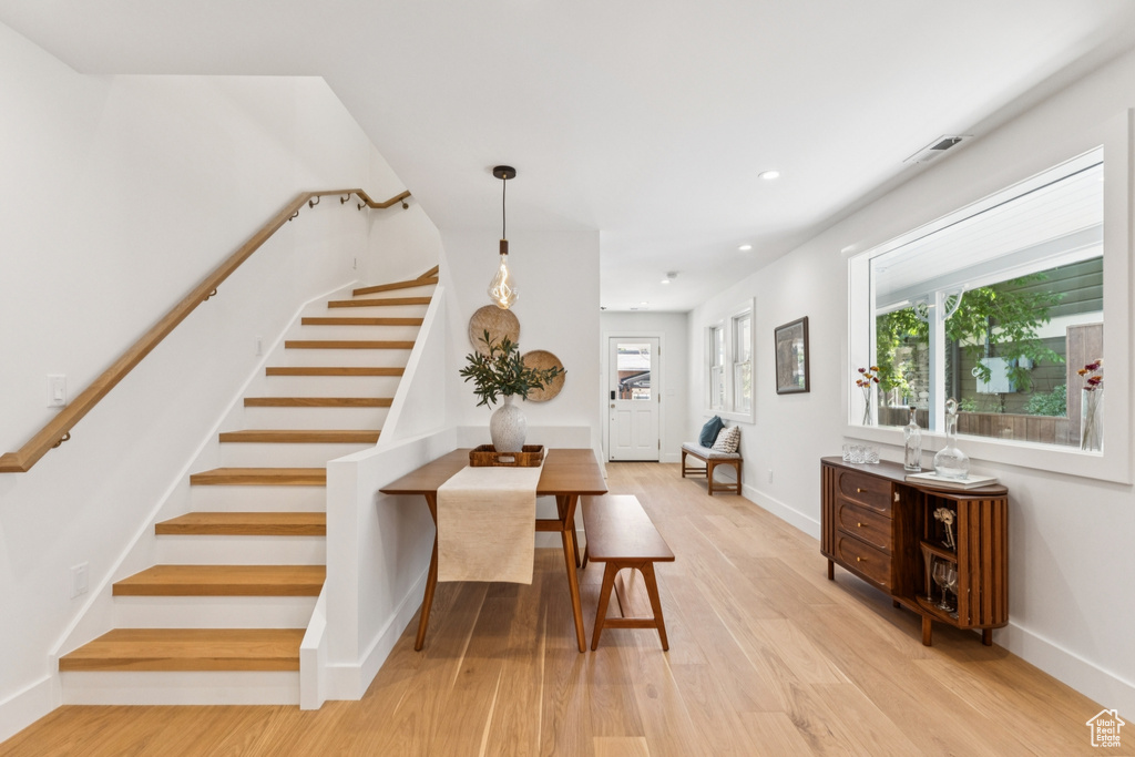 Dining space featuring stairs, light wood-style flooring, healthy amount of natural light, and recessed lighting