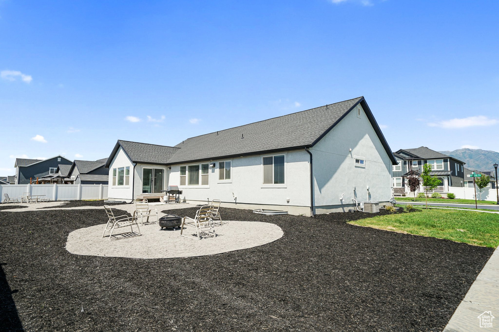Back of property featuring an outdoor fire pit, a patio, stucco siding, and a residential view