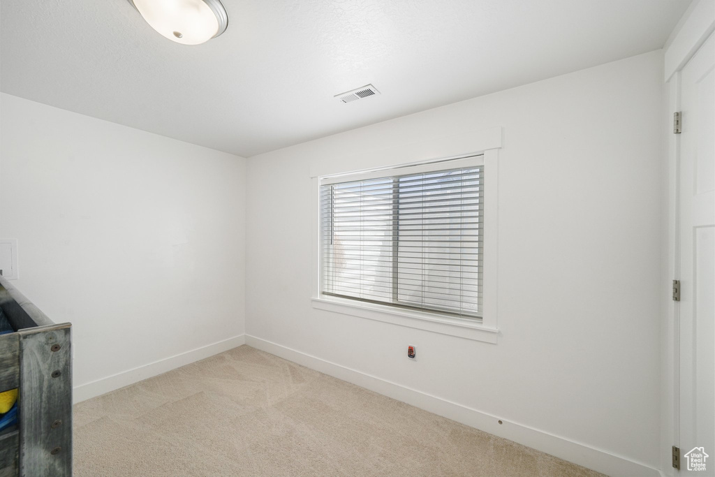 Unfurnished room featuring light colored carpet and baseboards