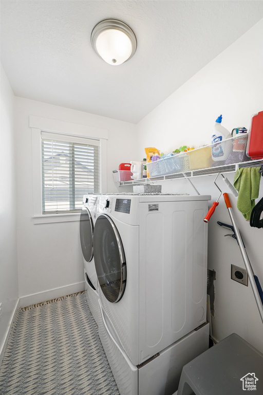 Washroom with separate washer and dryer and baseboards