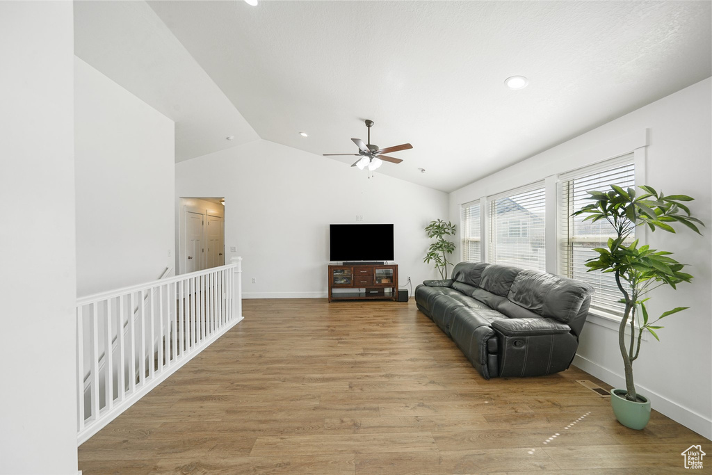 Living area with lofted ceiling, a ceiling fan, light wood-type flooring, and recessed lighting