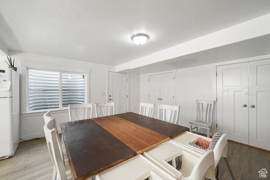 Dining area with light wood-style flooring and a textured ceiling