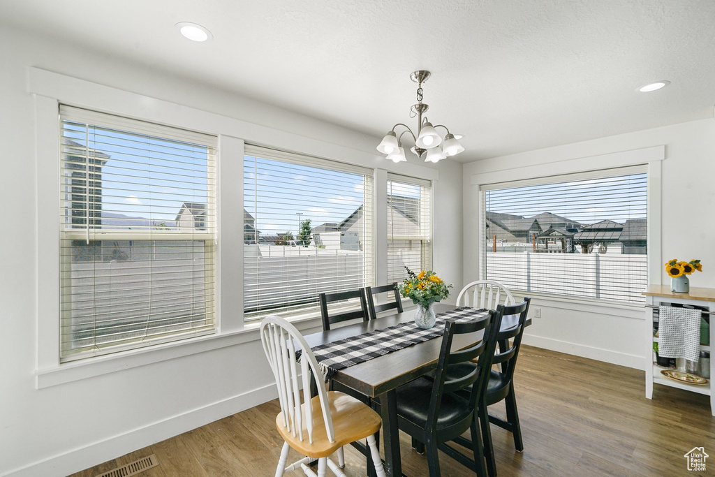 Dining room featuring a chandelier, wood finished floors, and recessed lighting