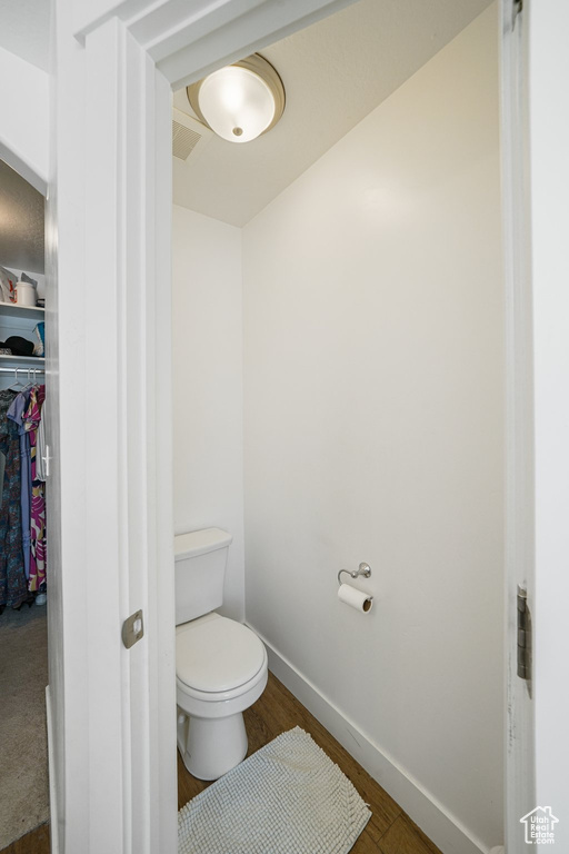 Bathroom with toilet and wood finished floors