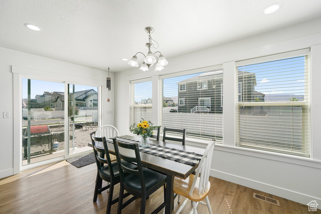 Dining area featuring wood finished floors, a chandelier, and recessed lighting