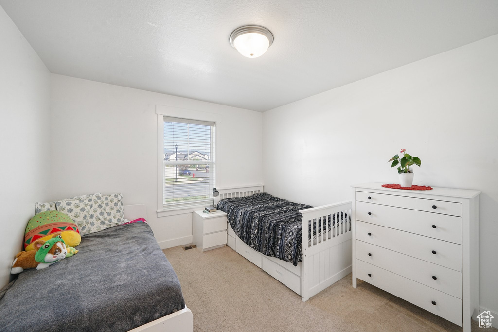 Bedroom featuring light colored carpet and baseboards