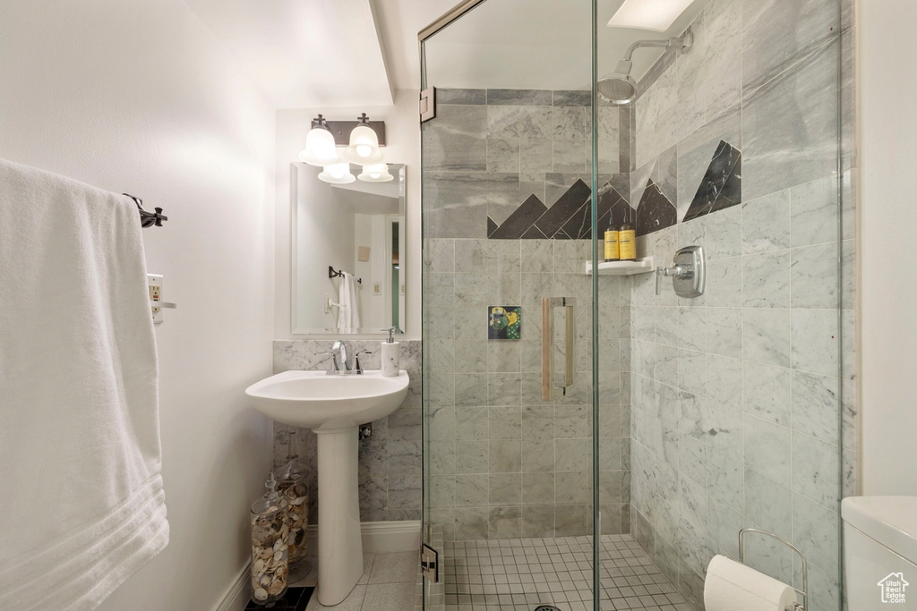 Full bathroom with a shower stall and tile patterned floors