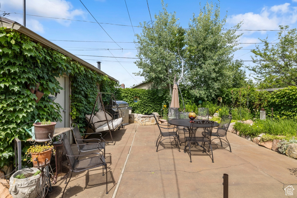 View of patio with outdoor dining area and a grill