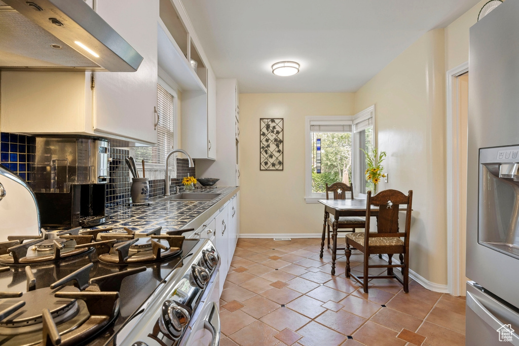 Kitchen featuring extractor fan, stainless steel fridge, range, and plenty of natural light