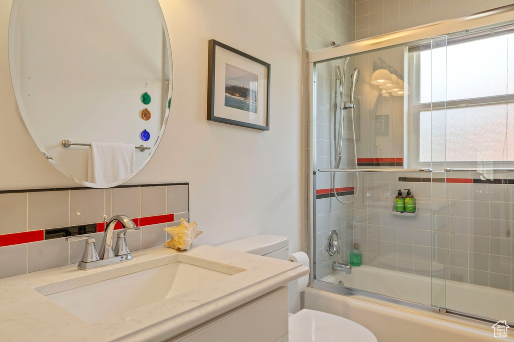 Bathroom featuring shower / bath combination with glass door and vanity