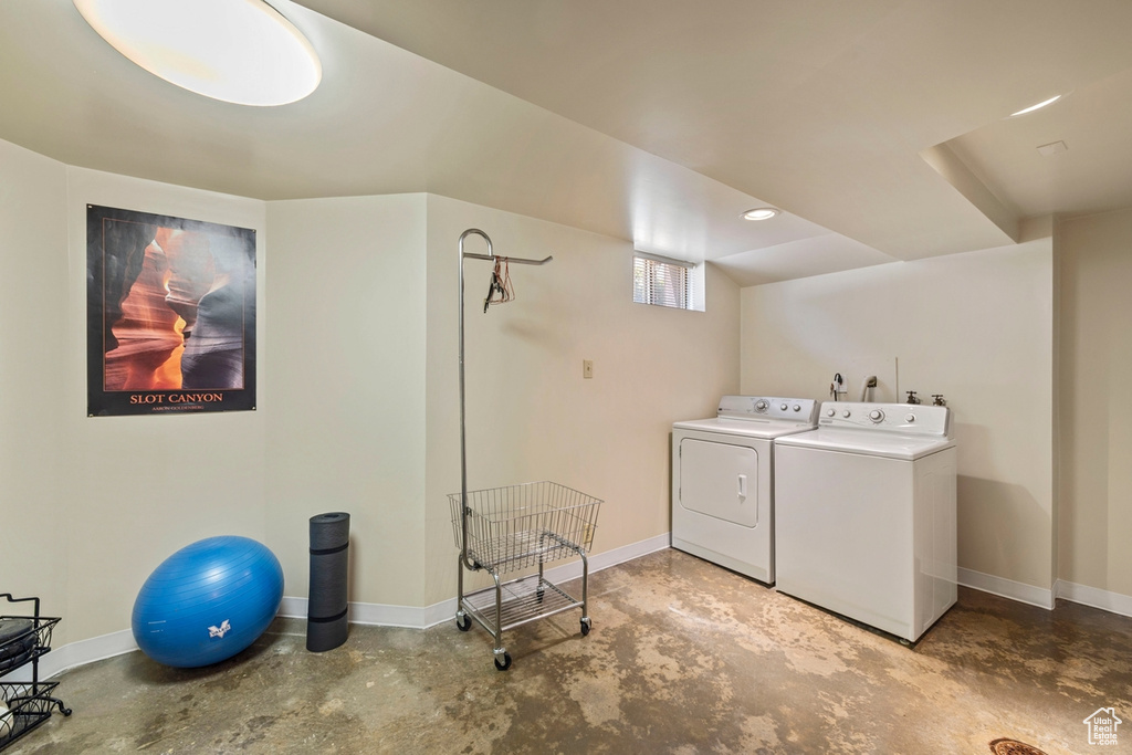 Washroom with washing machine and clothes dryer and baseboards