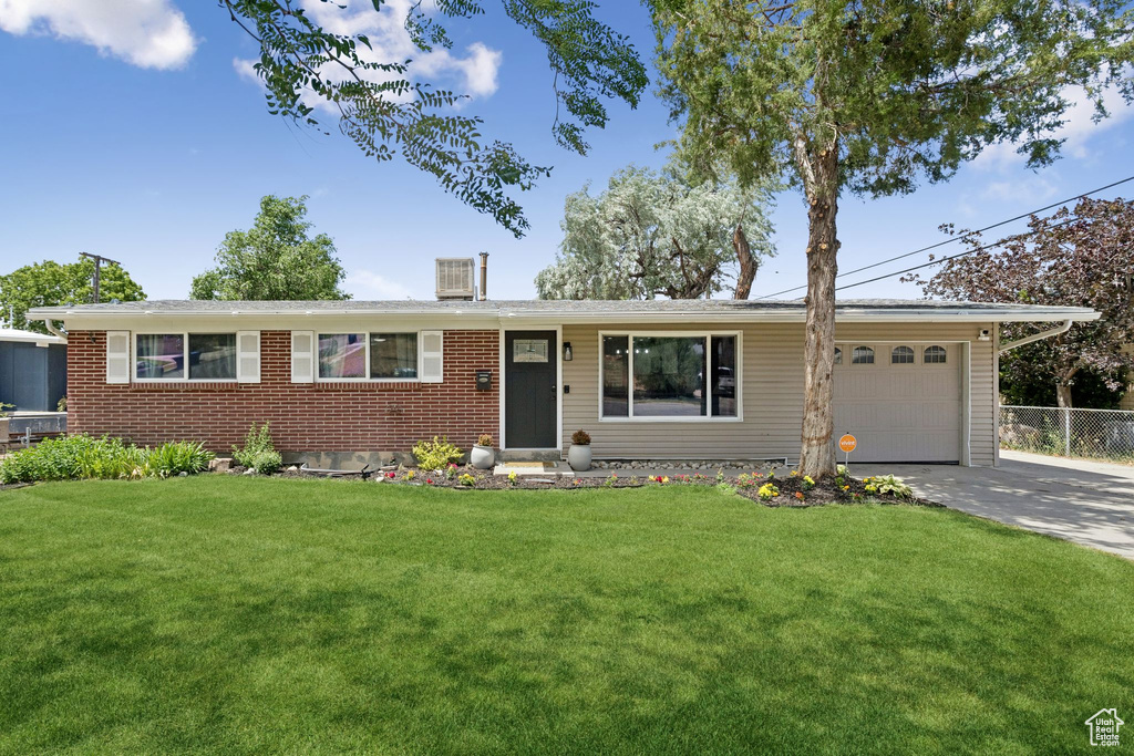 Ranch-style home featuring a garage, concrete driveway, and brick siding