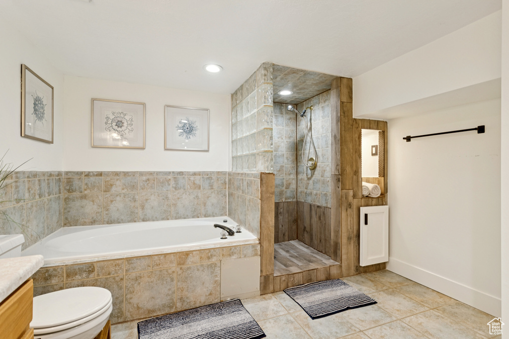 Full bathroom with a bath, tiled shower, vanity, and tile patterned flooring