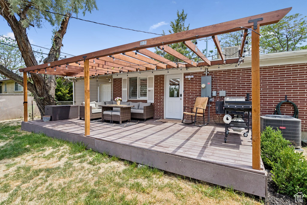 Wooden deck with outdoor lounge area, a pergola, and grilling area
