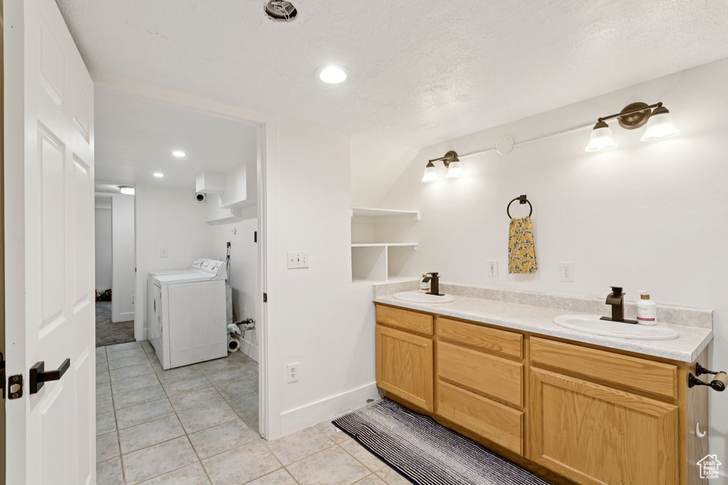 Bathroom featuring independent washer and dryer, tile patterned flooring, recessed lighting, and double vanity