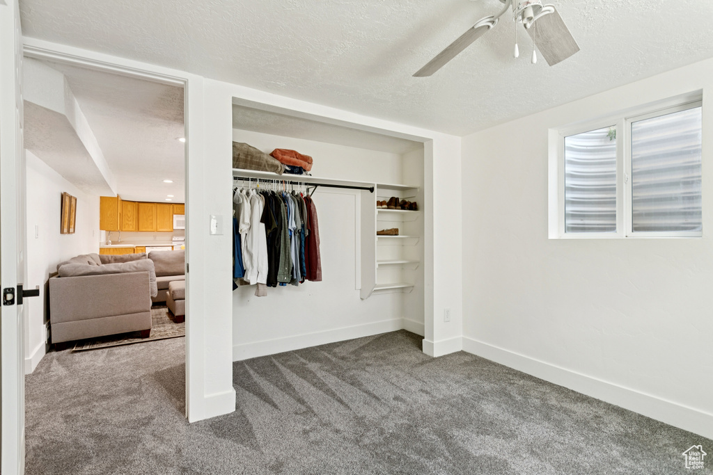 Bedroom with carpet flooring, a textured ceiling, a closet, and a ceiling fan