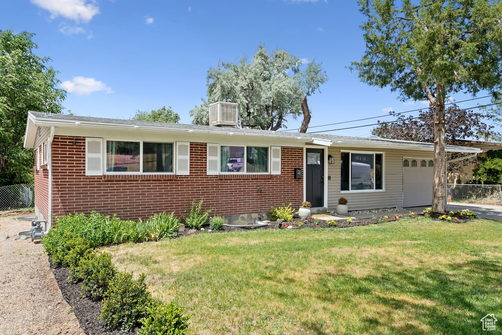 Single story home with an attached garage, a chimney, brick siding, and asphalt driveway