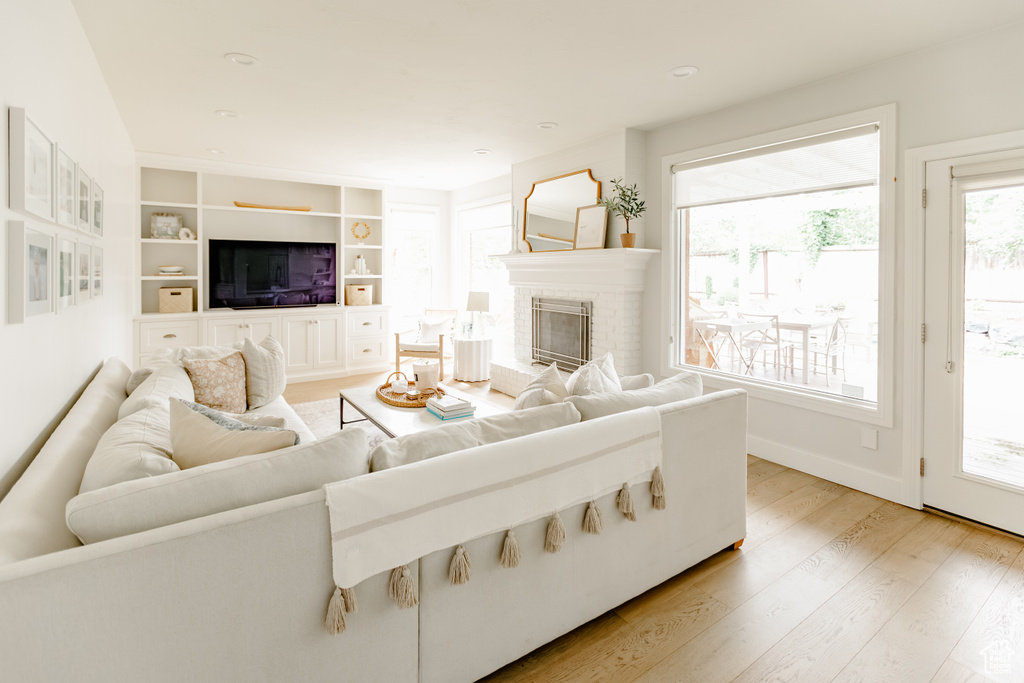 Living room with light wood-type flooring and a fireplace