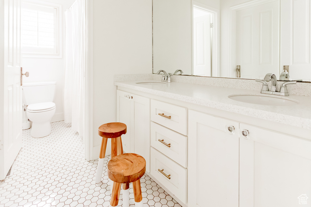 Full bathroom featuring double vanity and tile patterned flooring