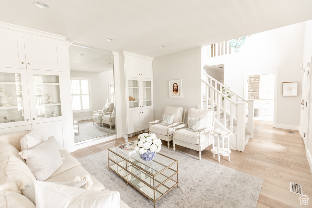 Living area featuring light wood-style flooring, stairway, and recessed lighting