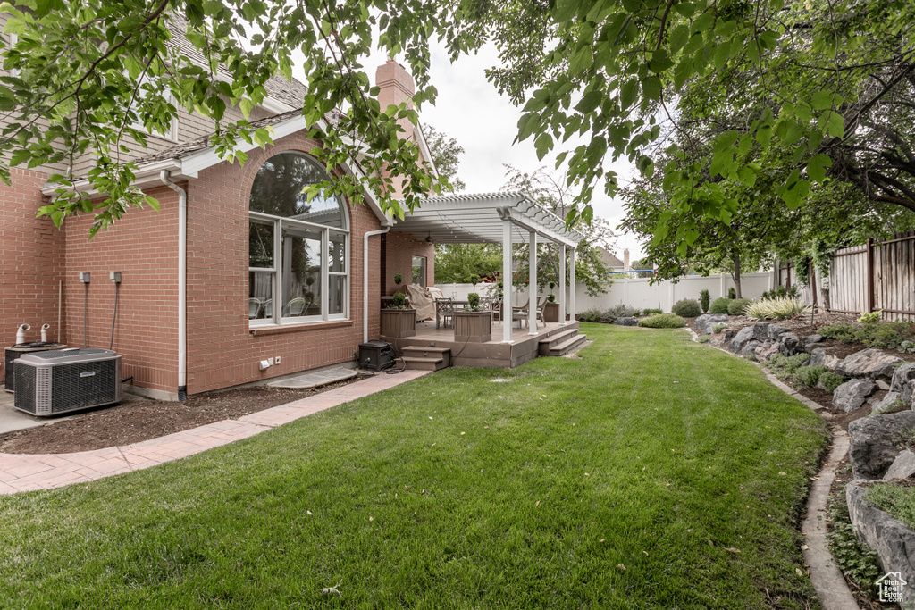 Fenced backyard with a pergola, a wooden deck, and a patio area
