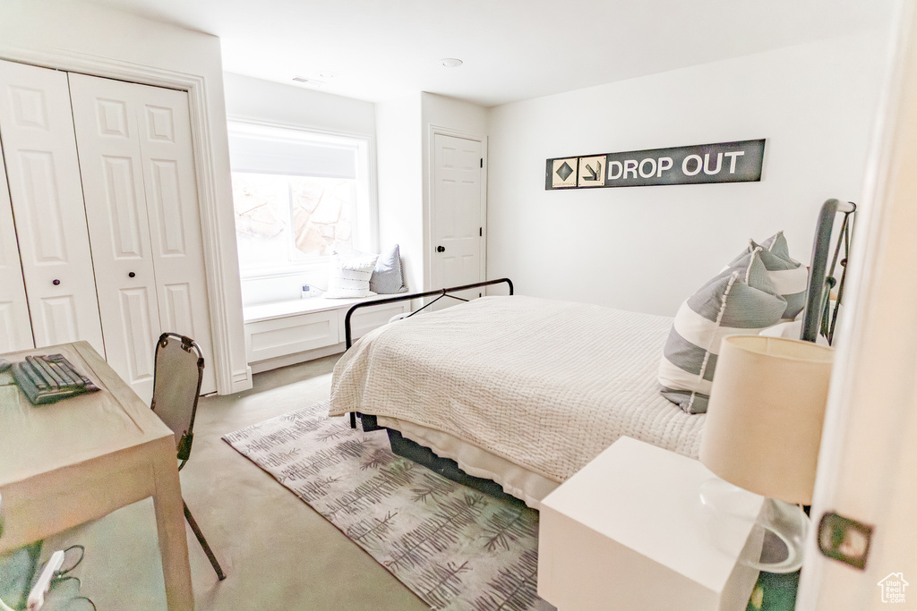 Bedroom featuring light carpet and a closet