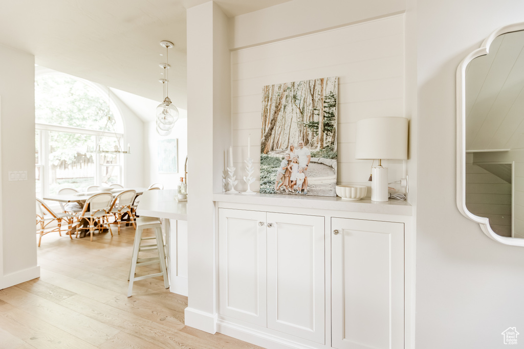Hallway featuring light wood-style floors and vaulted ceiling