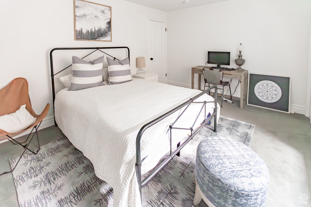 Carpeted bedroom with baseboards and an office area