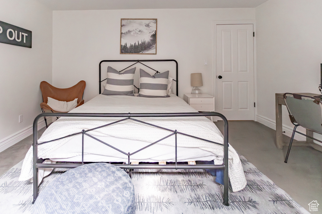 Bedroom featuring baseboards and concrete flooring