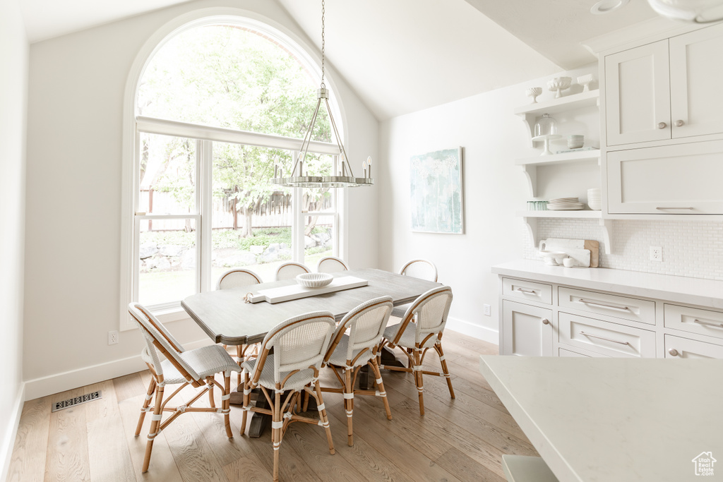 Dining room featuring lofted ceiling and light wood-style flooring